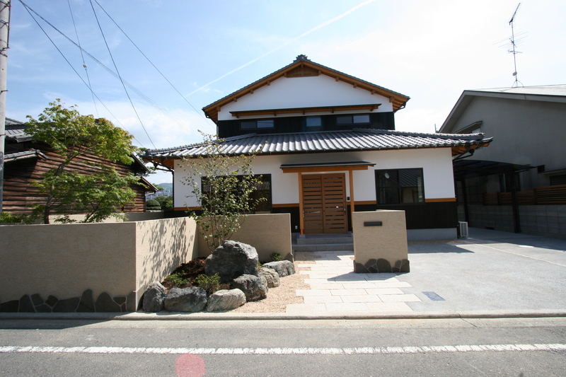 土壁をつけ焼杉と漆喰で仕上げウッドデッキのある伝統和風住宅